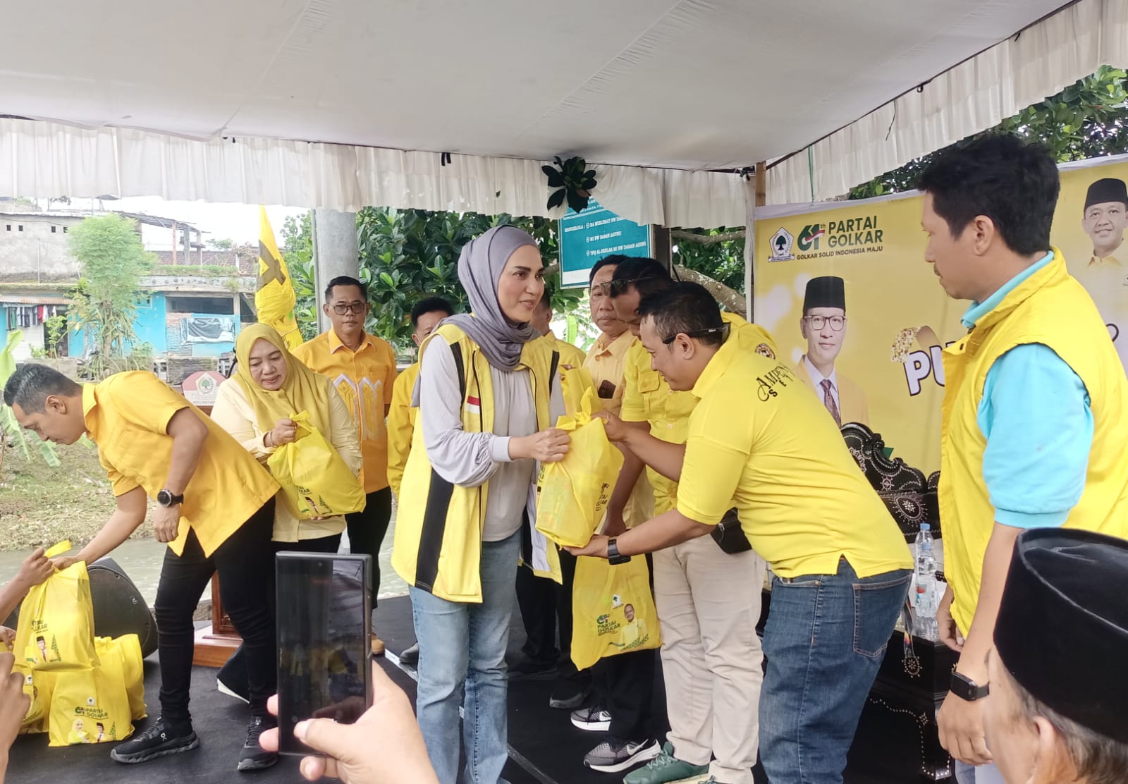 BANTUAN : Anggota DPR RI dari Partai Golkar Hj Sari Yuliati membagikan bingkisan bersisi bahan kebutuhan pokok dalam rangka HUT Partai Golkar ke 61 di Kelurahan Dasan Agung, Kota Mataram, Jumat (19/12