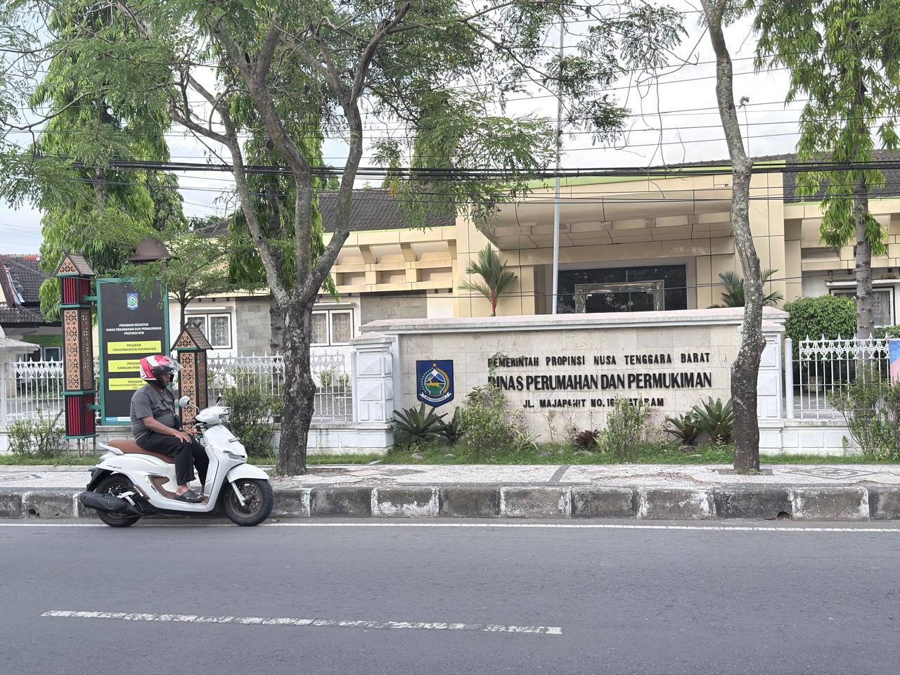 TERDAMPAK SOTK BARU: Seorang pengendara sepeda motor, berhenti sejenak di depan kantor Dinas Perumahan dan Permukiman (Perkim) NTB, beberapa waktu lalu.