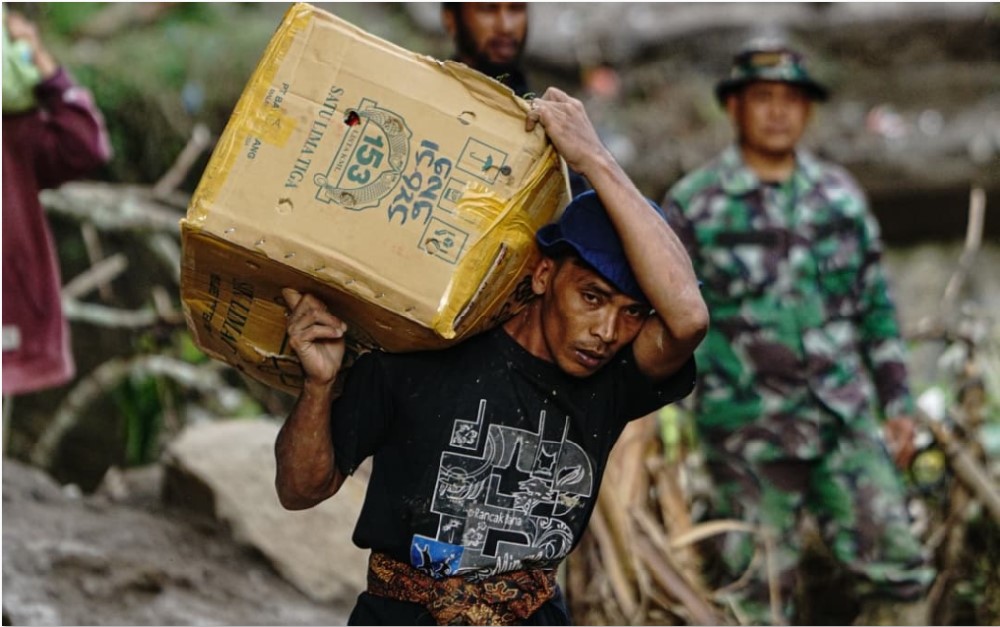 MANFAATKAN PELUANG: Buruh pikul membawa barang melintasi kawasan Tenge Besi, Kecamatan Pintu Rime Gayo, Bener Meriah. Warga dari Bener Meriah menuju Bireun dan harus mengangkut barang bawaan.