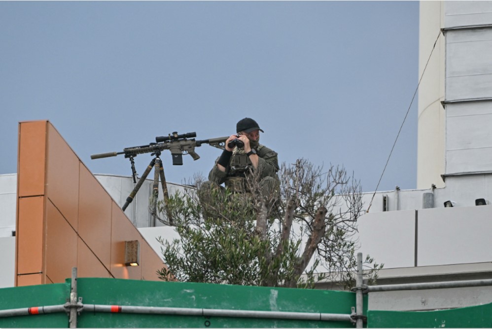 SIAGA: Polisi penembak jitu mengamankan area Pantai Bondi, Sidney, Australia, Senin (21/12). (AFP/JAWA POS)