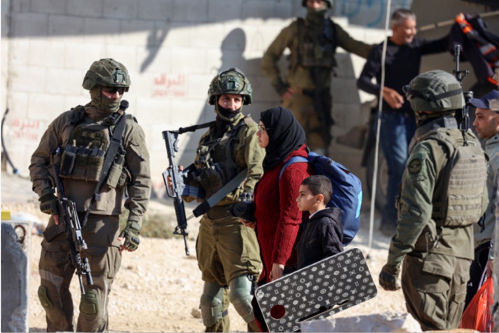PENGAMANAN KETAT: Tentara Israel memeriksa seorang ibu dan anak yang berjalan di Tepi Barat,&nbsp;Senin (22/12).Israel akan membangun permukiman baru di kawasan tersebut cegah pembentukan negara Palestina.