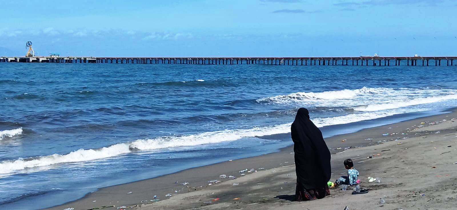 Seorang pengunjung bersama anaknya menikmati kawasan wisata yang ada di Pantai Viral Bagek Kembar, Tanjung Karang, Kota Mataram, Selasa (23/12). (NURUL/LOMBOK POST)