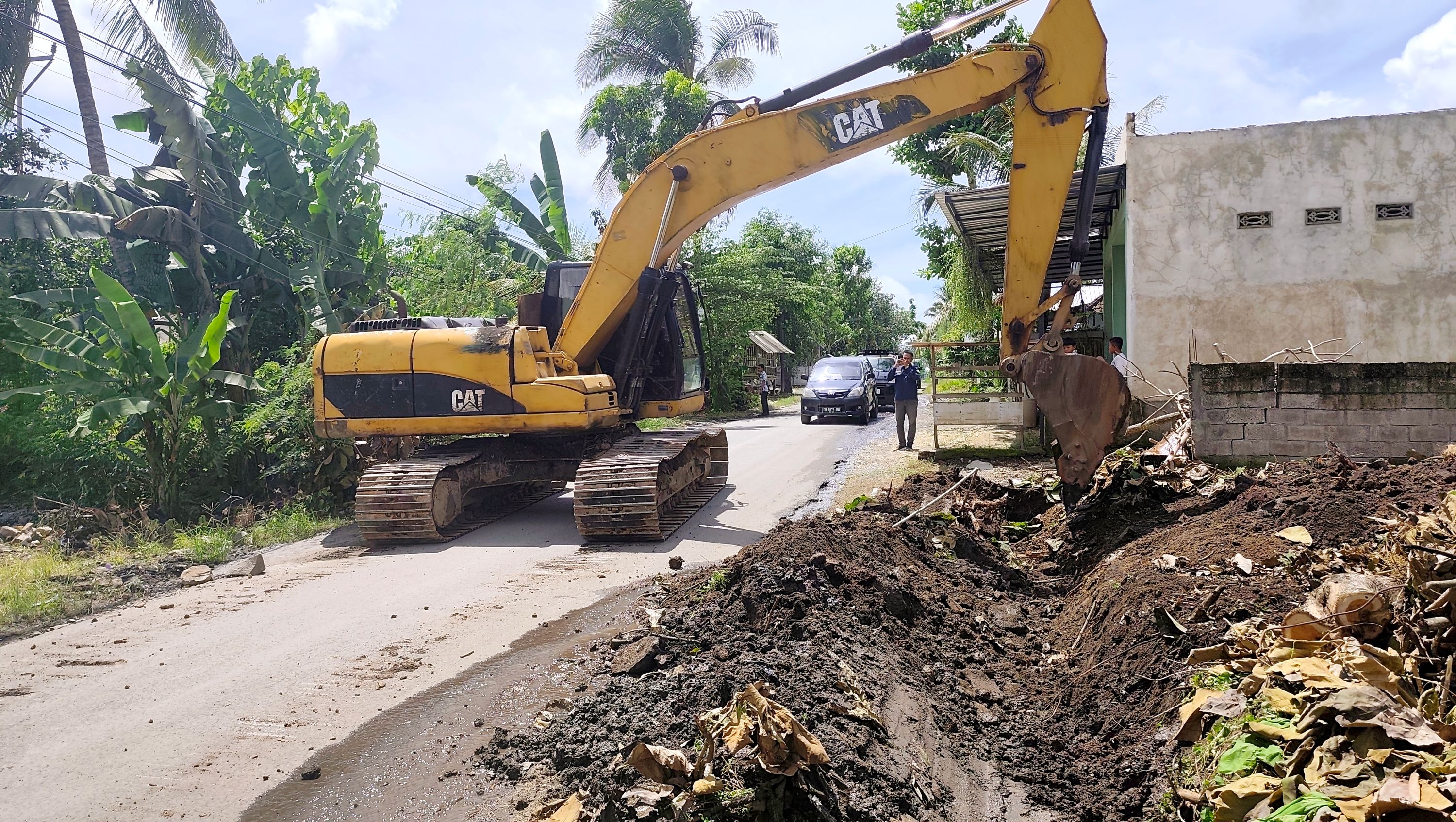 Alat berat eskavator menggali sejumlah titik drainase yang tertimbun tanah dan sampah di sepanjang jalan raya wisata Penujak-Selong Belanak di Desa Bonder, Praya Barat, Lombok Tengah, Selasa (23/12).