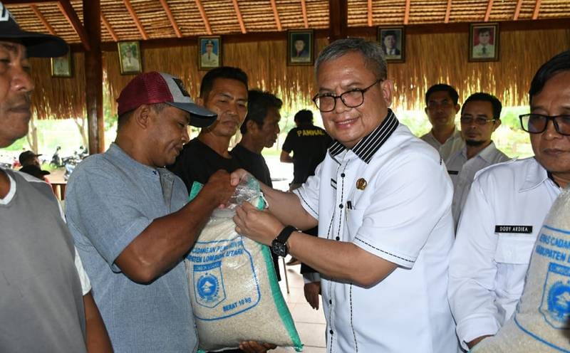 STOK CUKUP: Kepala DKP3 KLU Tresnahadi menyalurkan beras CPP kepada nelayan saat cuaca buruk, pada Bulan Maret 2025 lalu.