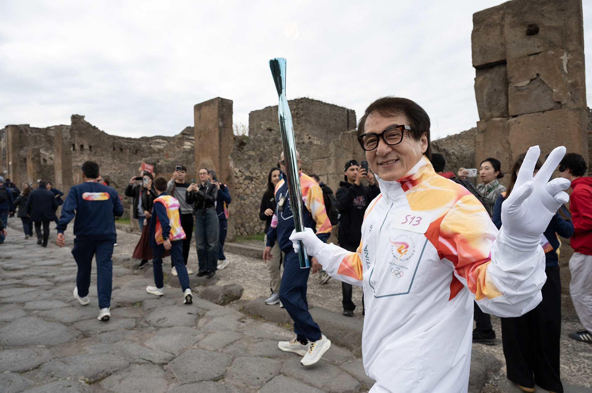 Jackie Chan, memegang Obor Olimpiade di kawasan arkeologi Pompeii, Italia, dalam rangka kirab Obor Olimpiade. (AFP PHOTO / SOURCE / BYLINE)