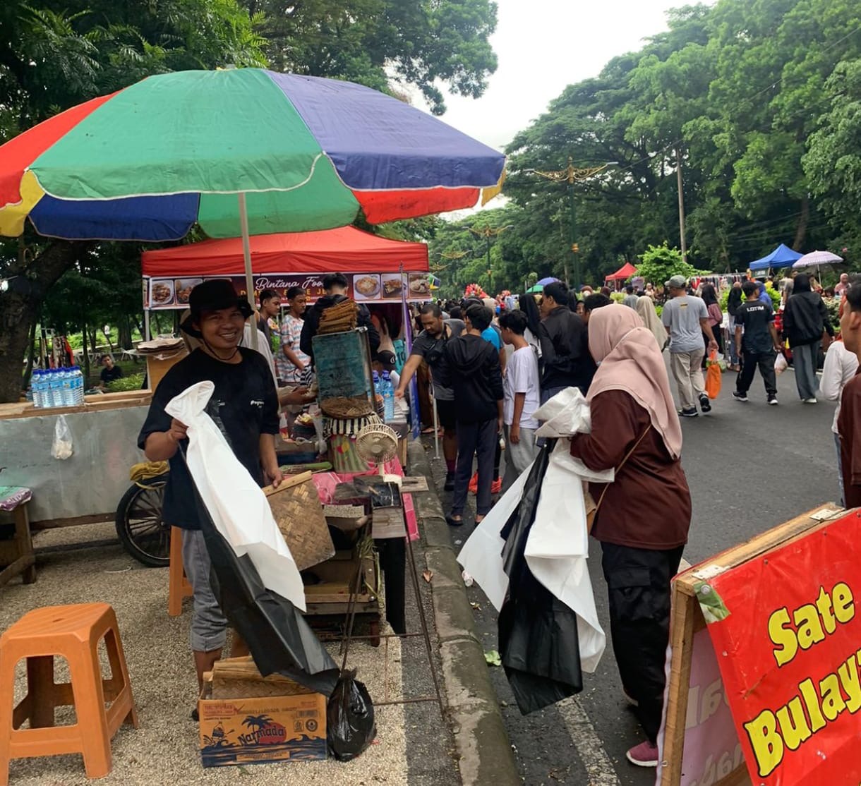 Relawan tengah membagikan dua kantong sampah warna putih dan hitam di CFD Udayana Kota Mataram.