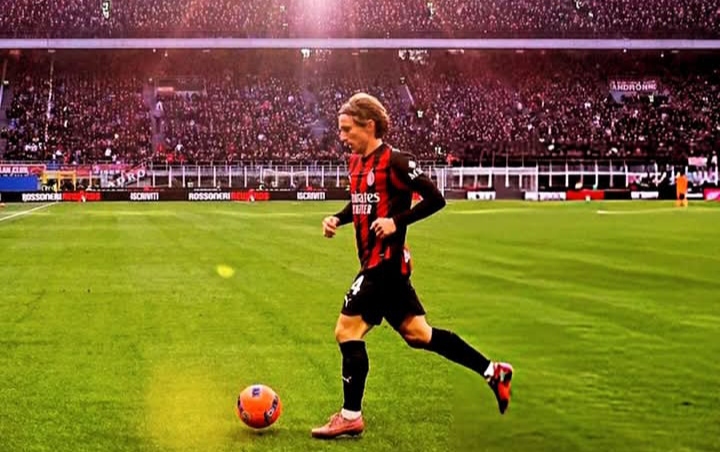 Luka Modric menggiring bole di hadapan puluhan ribu fans AC Milan dalam laga kontra Hellas Verona. 