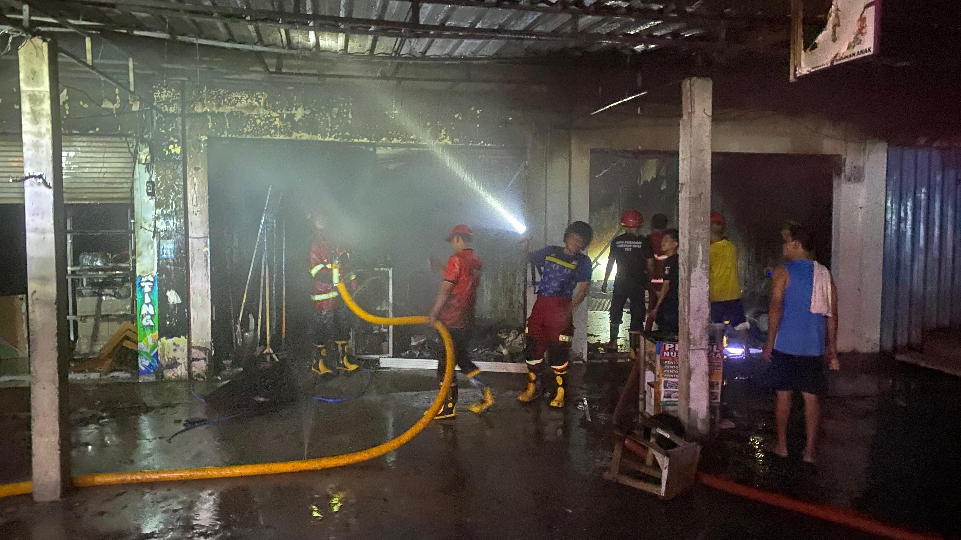 Petugas Damkartan Loteng berjibaku padamkan si jago merah di kawasan pertokoan Desa Mujur, Praya Timur, Loteng, Senin (29/12).