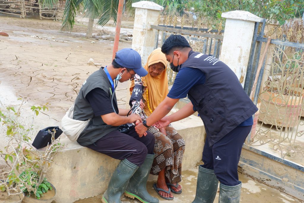 Tim medis UMMAT saat melakukan layanan mobile pengecekan kesehatan warga korban banjir di Aceh Tamiang.