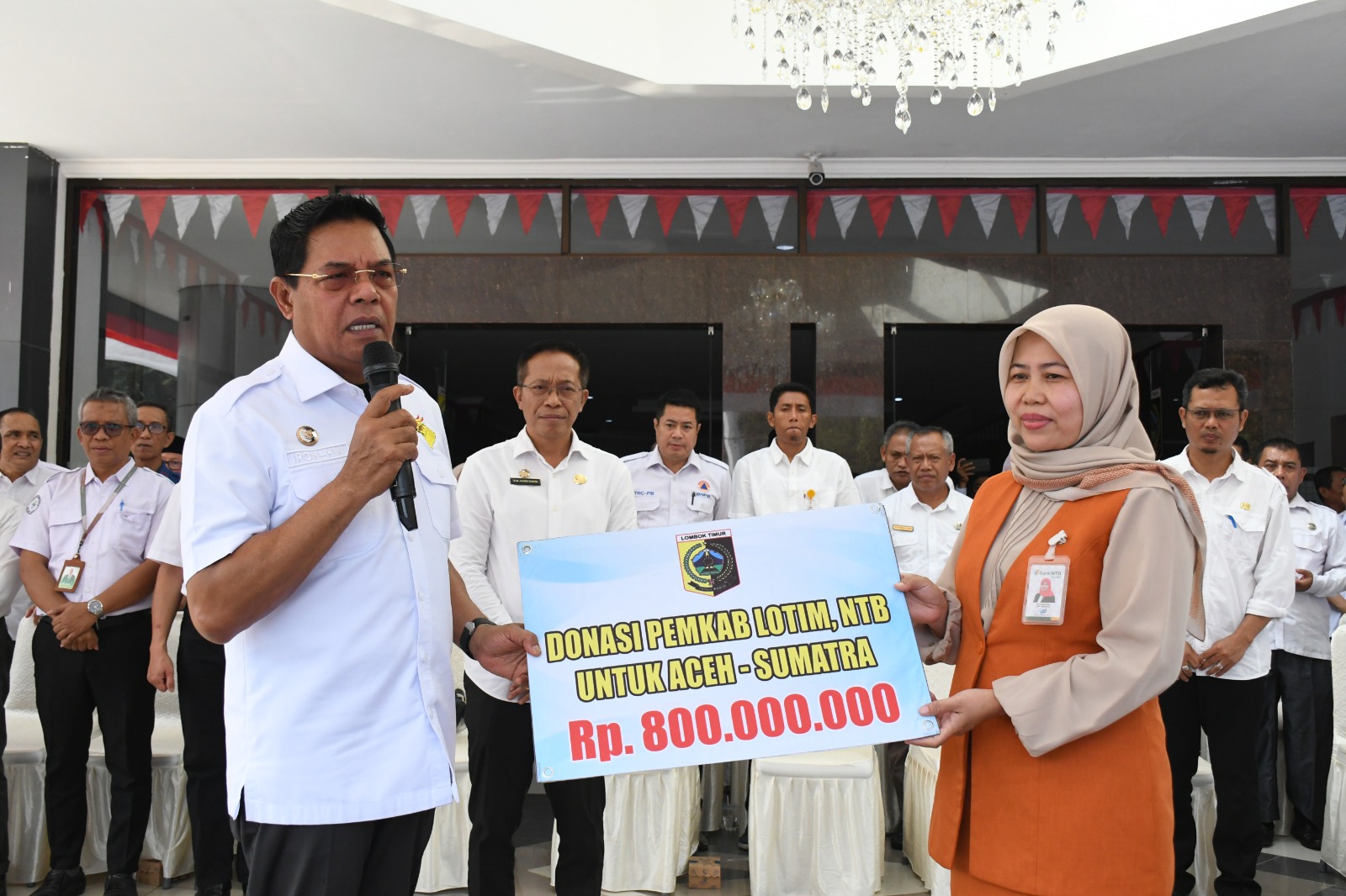 Bupati Lotim Haerul Warisin saat menyerahkan donasi kepada pimpinan Bank NTB untuk korban banjir Sumatera dan Aceh