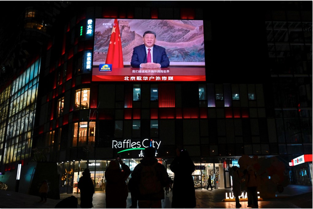 PIDATO AKHIR TAHUN: Warga Tiongkok menyaksikan dari layar besar Presiden Xi Jinping berpidato menjelang perayaan malam Tahun Baru di Beijing, Rabu (31/12). Xi Jinping menyampaikan rencana penyatuan.