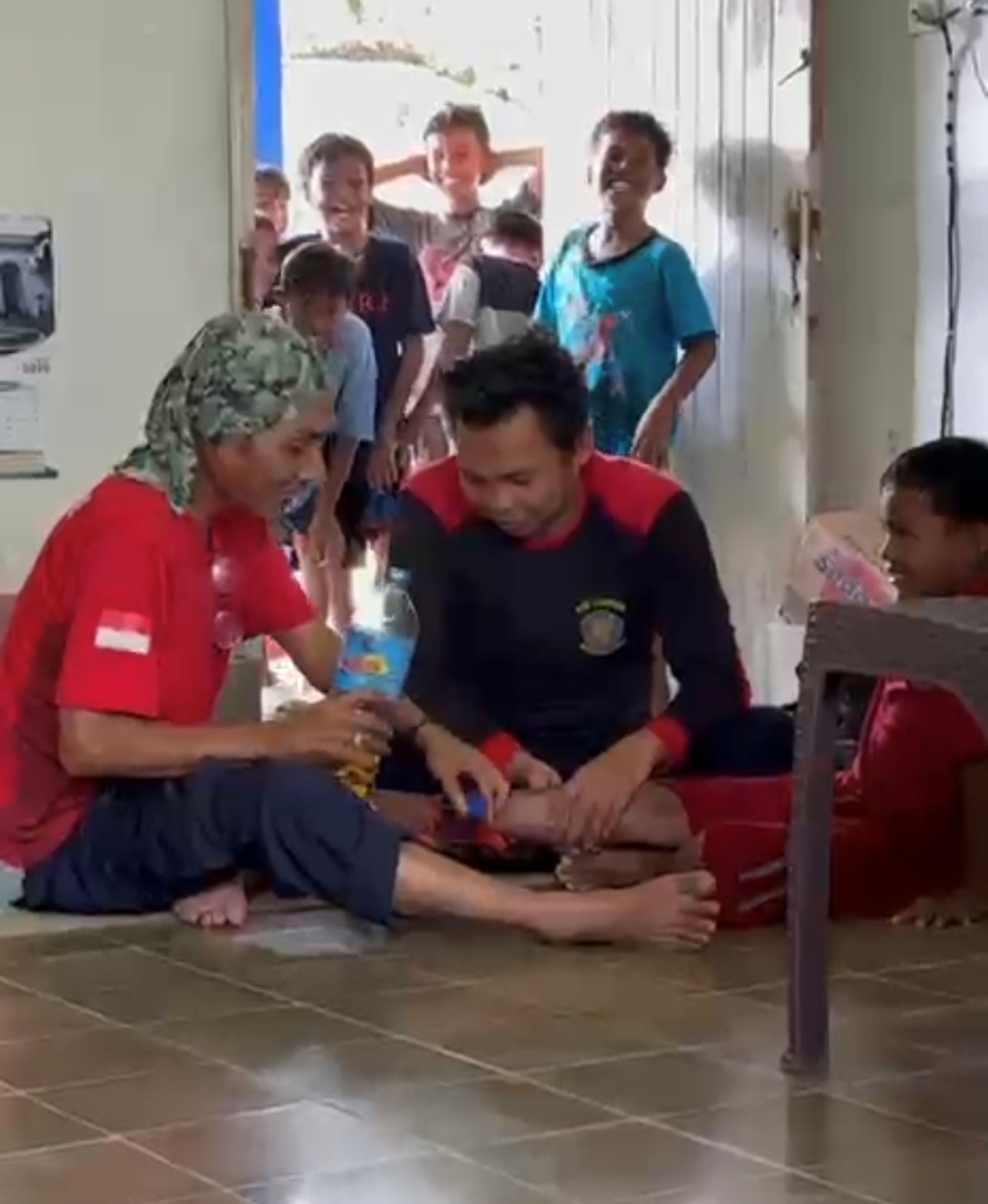Dua orang petugas Damkartan Lombok Tengah berupaya melepaskan sandal yang terjepit pada kaki seorang anak, beberapa waktu lalu.