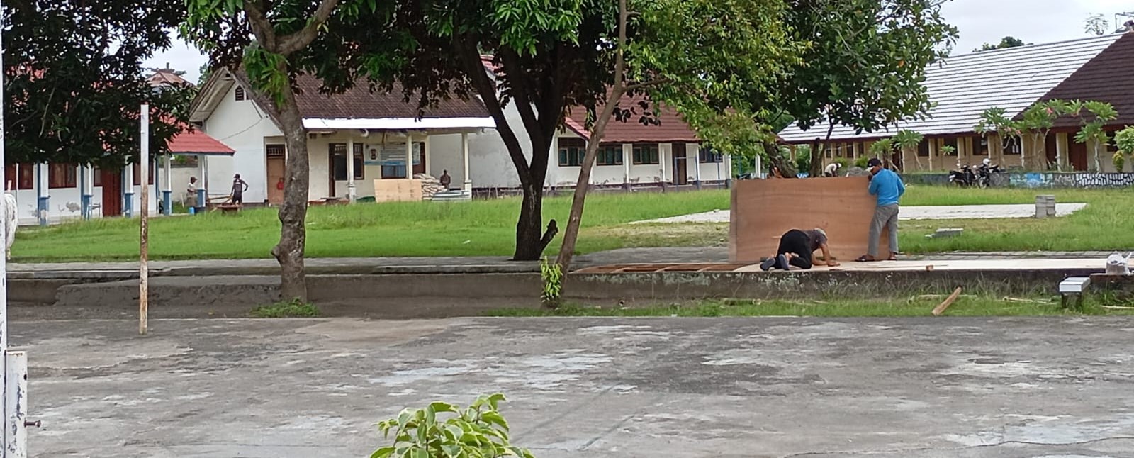 Dua orang pekerja membuat bekisting untuk pengecoran saluran di SMPN 20 Mataram, Selasa lalu (30/12). SMPN 20 Mataram ajukan revitalisasi delapan ruang kelas tahun 2026.