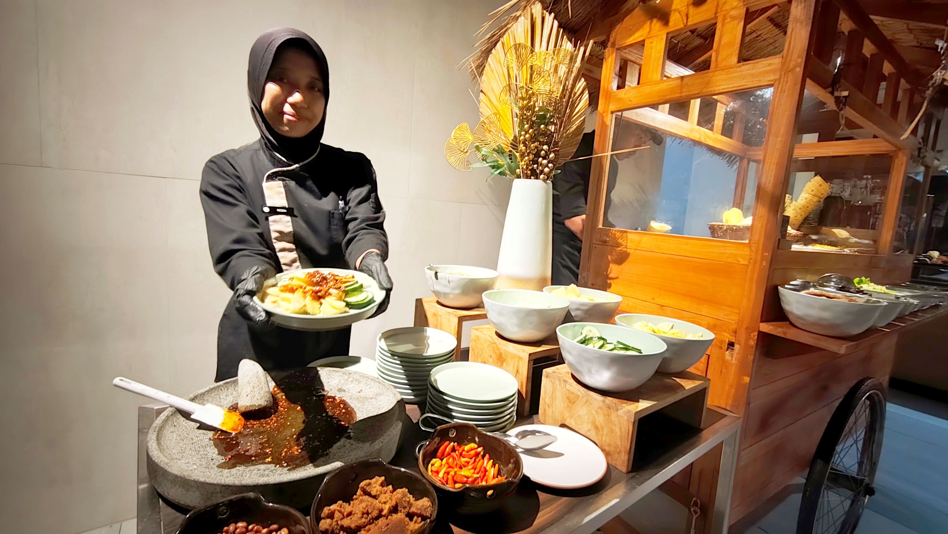 Waitress menunjukkan seporsi rujak buah segar bagi pengunjung di AER Restaurant, Pullman Lombok Merujani Mandalika Beach Resort.
