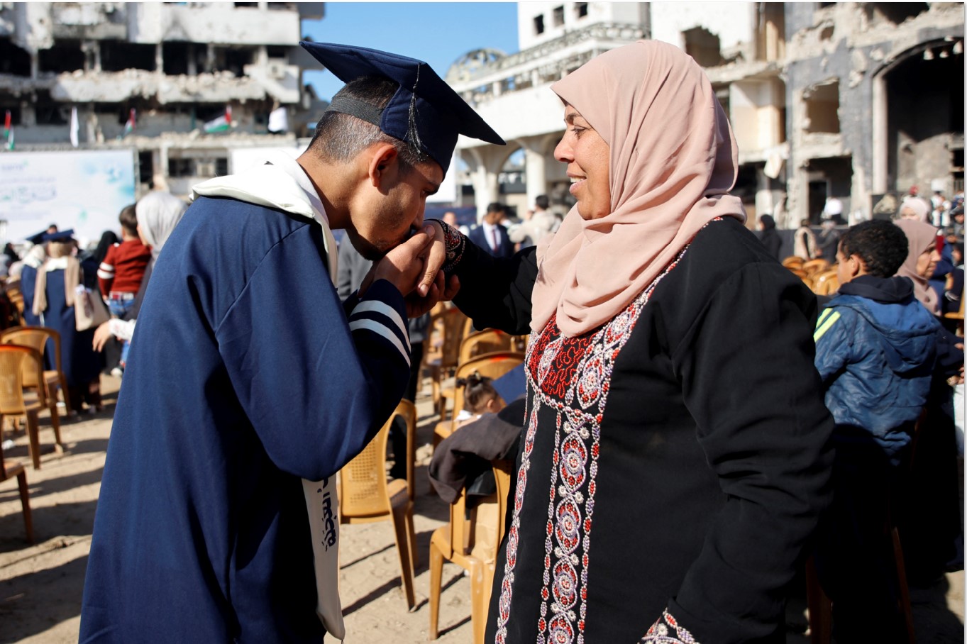 STUDI JALAN TERUS: Seorang mahasiswa Palestina dari Fakultas Kedokteran Universitas Islam Al-Azhar mencium tangan ibunya dalam wisuda di halaman Rumah Sakit Al-Shifa, Gaza, akhir pekan lalu.