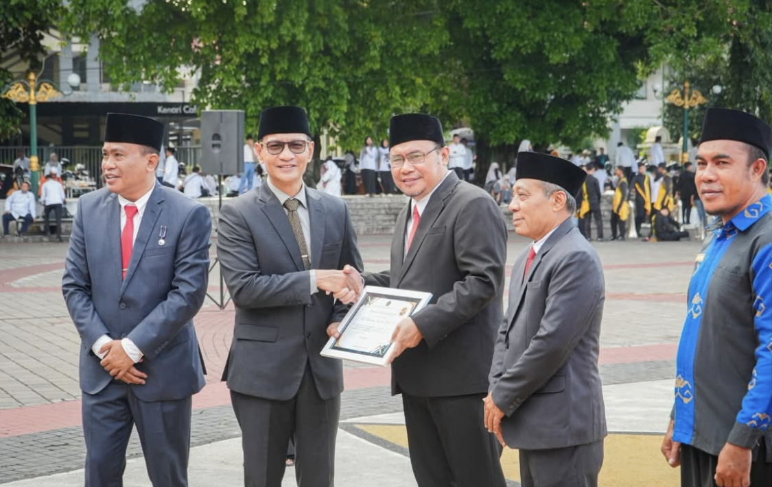 Wali Kota Mataram Mohan Roliskana saat menyerahkan penghargaan pada Hamdun atas kontribusi membangun Kota Wakaf.