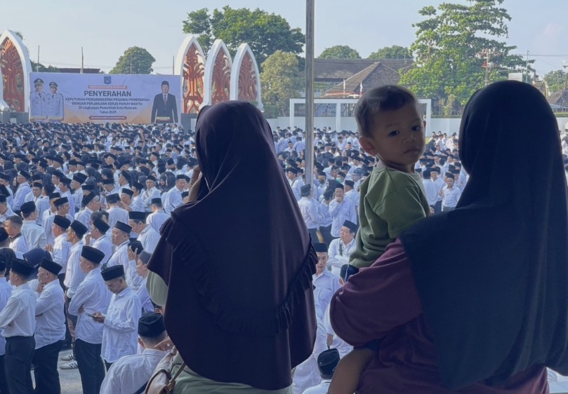 Dua warga menyaksikan ribuan PPPK paro waktu yang akan diangkat secara resmi oleh Wali Kota Mataram.