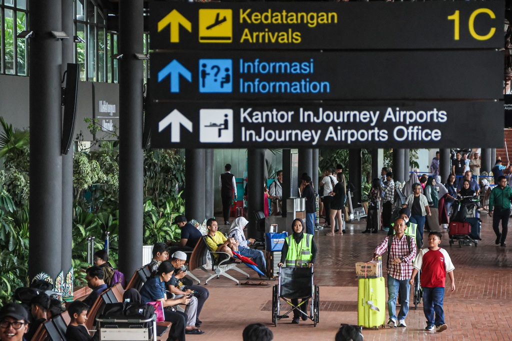 Sejumlah penumpang pesawat keluar dari Terminal 1C Bandara Soekarno-Hatta, Tangerang, Jumat (02/01/2026). Pengoelola Bandara Soetta mempredikai hari Sabtu dan Minggu besok menjadi puncak arus balik libur Natal dan Tahun Baru 2026 seiring sudah normal kemb