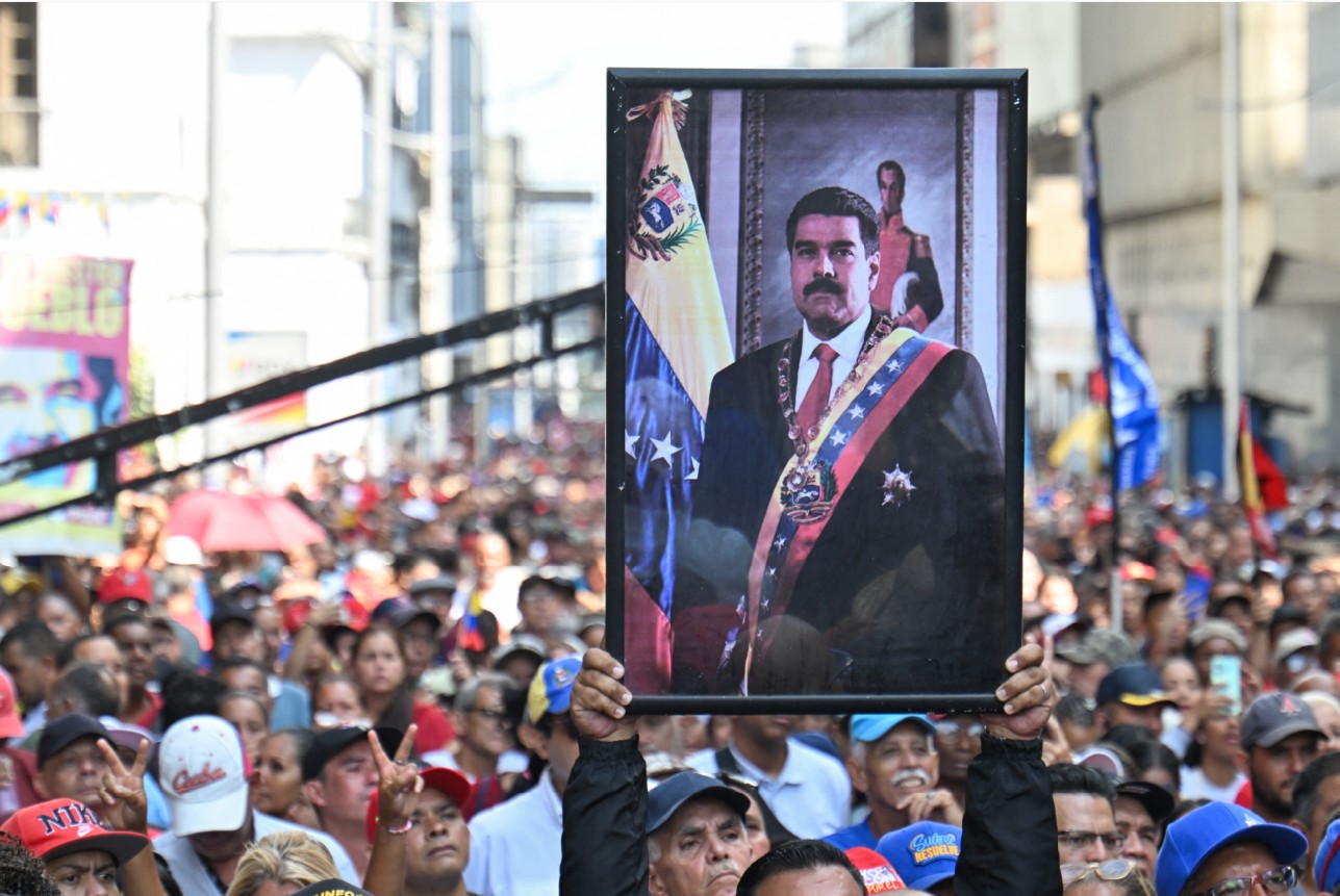 SIDANG PERTAMA: Seorang pendukung Nicolas Maduro bawa potret saat unjuk rasa di luar Majelis Nasional di Caracas, Senin (5/1). Parlemen Venezuela melantik Delcy Rodriguez sebagai Presiden Sementara.