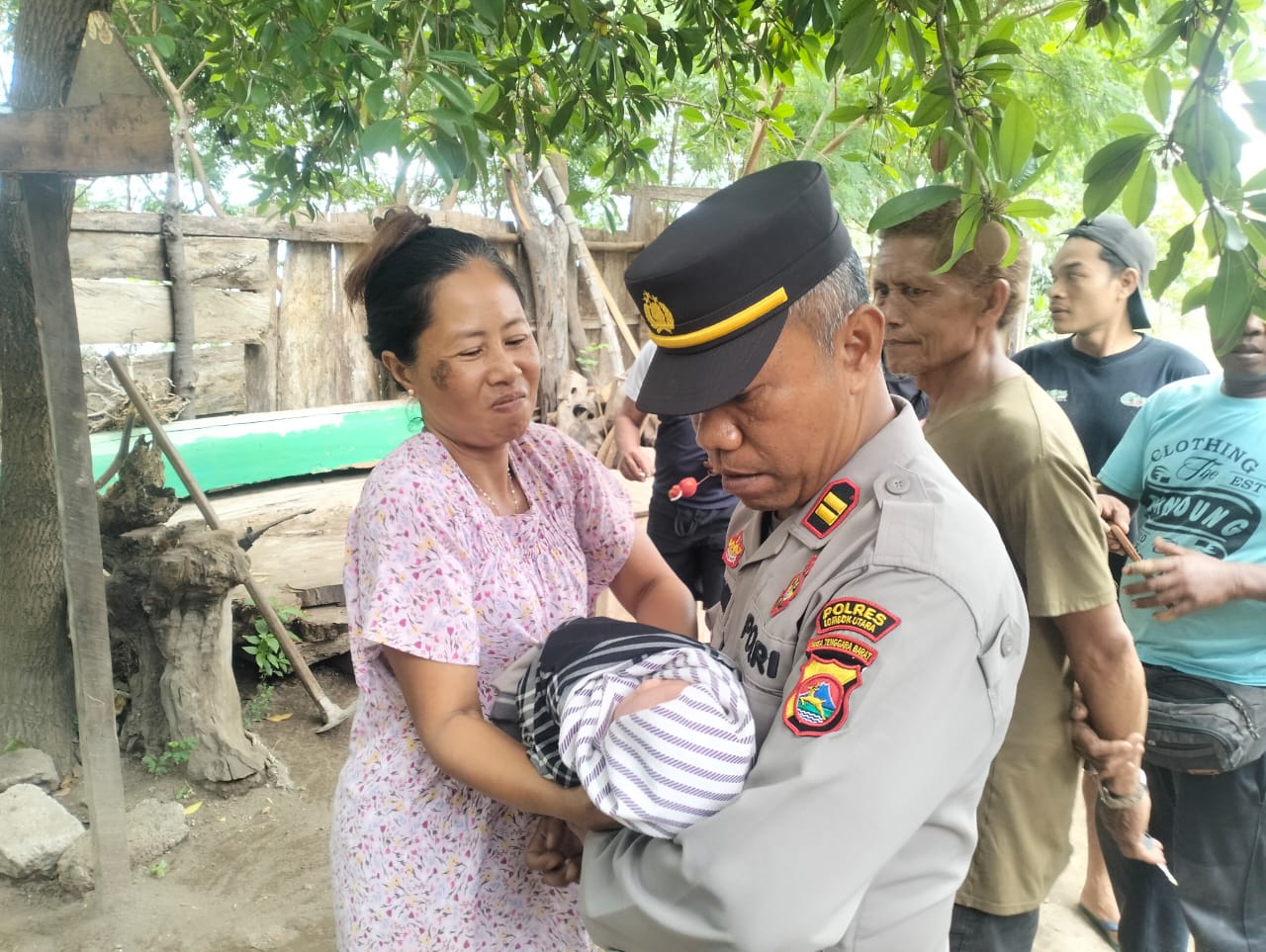 DISELAMATKAN: Kapolsek Kayangan AKP Zainuddin menggendong bayi yang ditemukan di atas teras dalam.kondisi dibungkus plastik