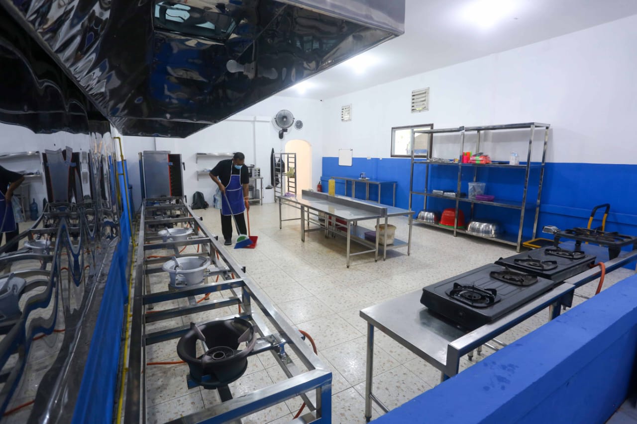 DAPUR WAJIB BERSIH: Seorang karyawan dapur MBG bersih-bersih di area kerjanya, beberapa waktu lalu.