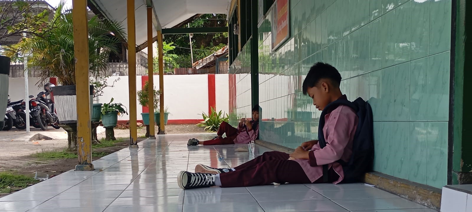Murid SDN 27 Cakranegara menunggu jemputan di teras sekolah setempat, Jumat (9/1). SDN 27 Cakranegara atur jadwal MBG untuk FDS.