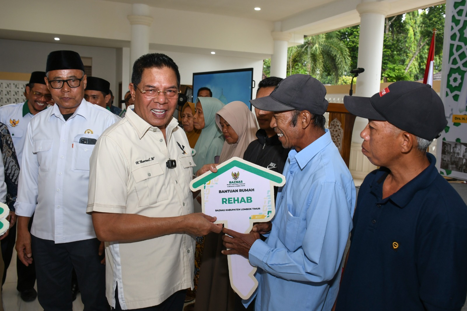 Bupati Lotim Haerul Warisin saat menyerahkan kunci rumah layak huni yang sudah direnovasi oleh Baznas