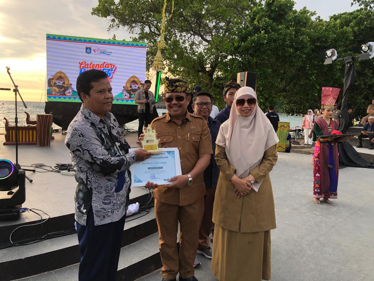 JUARA: Kades Lebah Sempage Muhammad Adi saat menerima penghargaan dari Bupati Lobar Lalu Ahmad Zaini saat penghargaan ADWI 2025 beberapa waktu lalu.