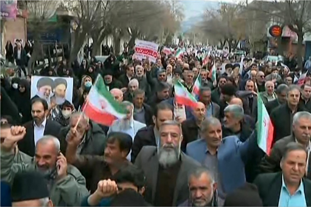 DEMO: Tangkapan layar rekaman video yang dirilis oleh Iran Press menunjukkan para demonstran pro-pemerintah meneriakkan slogan-slogan saat mereka berbaris di sepanjang jalan utama.