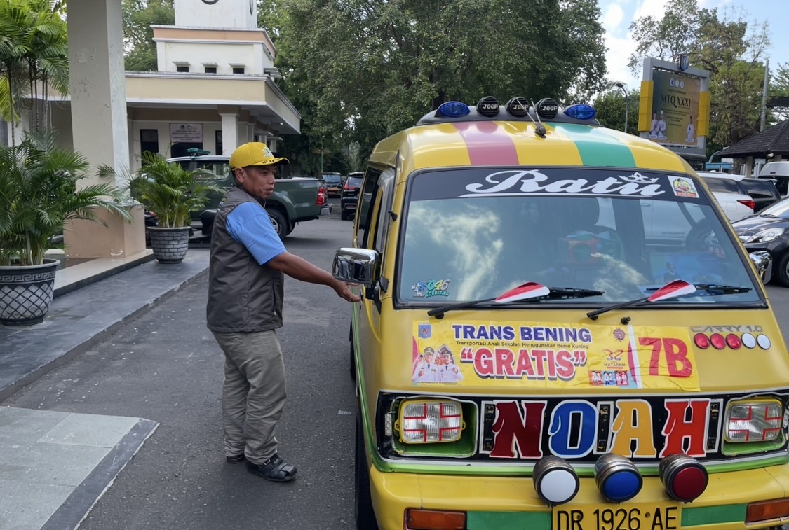 Driver Trans Bening membuka pintu mobil untuk menjemput anak sekolah, beberapa waktu lalu.