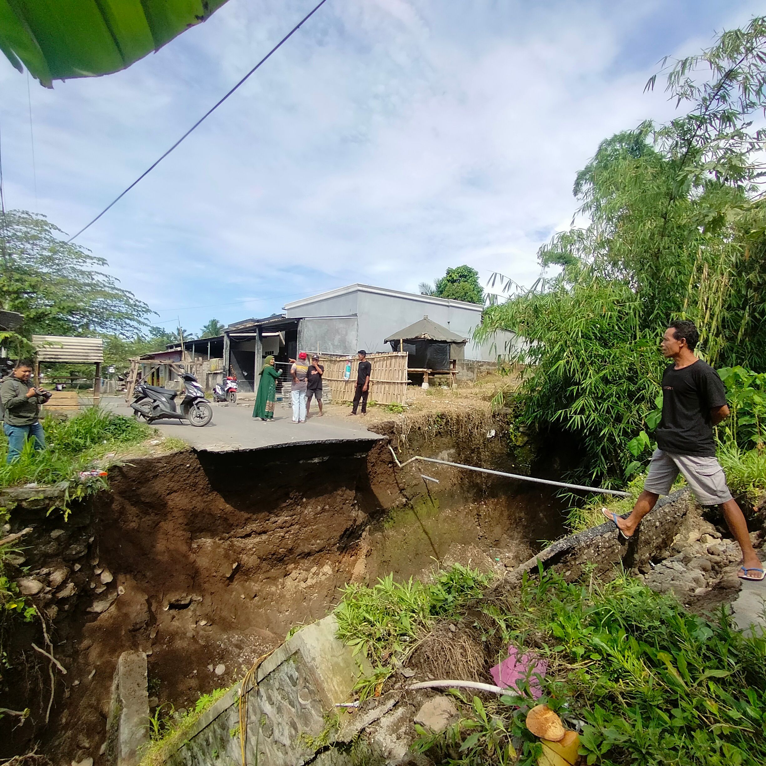Sejumlah warga saat melihat kondisi jembatan pengunjung kecamatan Masbagik dengan Kecamatan Pringgasela yang ambruk secara tiba-tiba, Minggu (11/1).