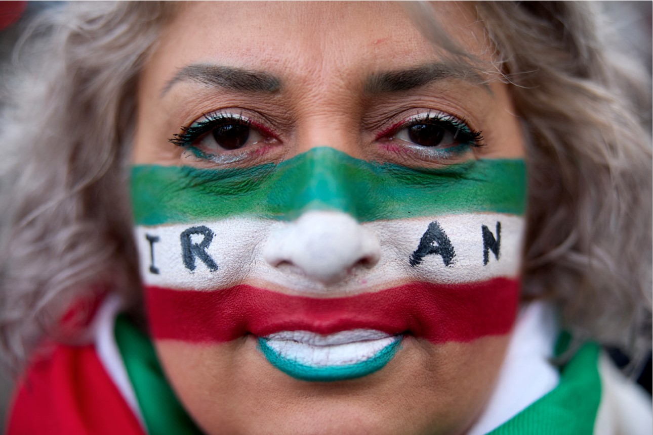 UNJUK RASA: Seorang demonstran perempuan mengecat wajahnya dengan warna bendera Iran dan kata