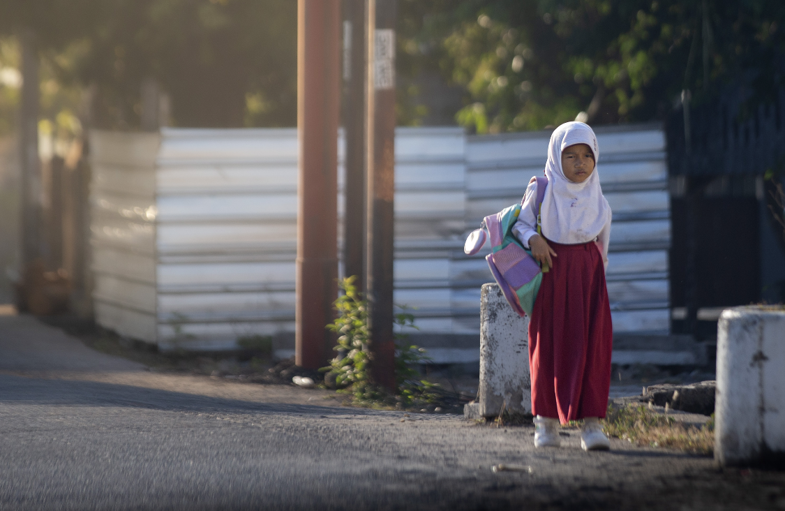 Seorang siswa tengah berangkar sekolah pada pagi hari.