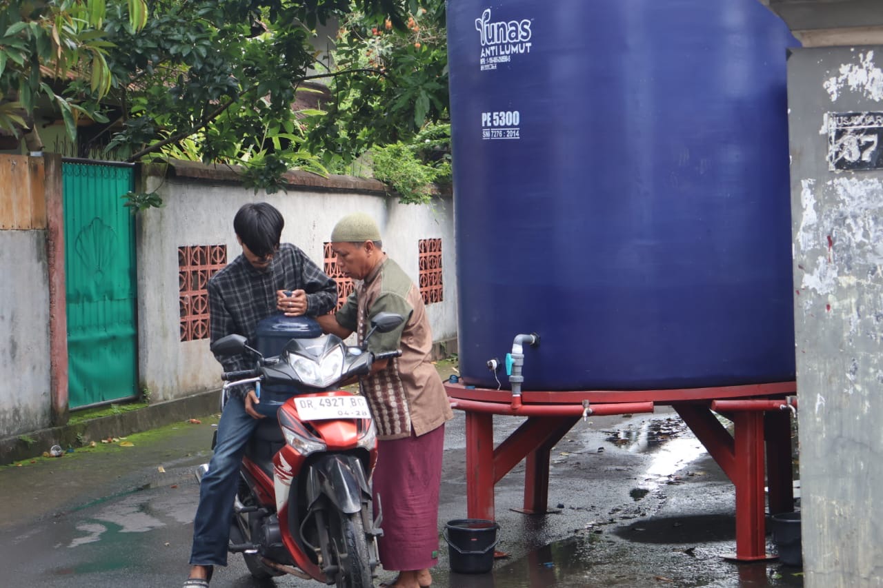 Warga Rembiga mengambil air bersih menggunakan galon di tanki air yang disiapkan pemkot.
