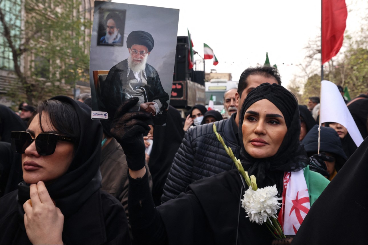 TURUT BERDUKA: Seorang wanita Iran memegang potret Pemimpin Tertinggi Iran Ayatollah Ali Khamenei saat upacara pemakaman personel pasukan keamanan yang tewas ketika mengamankan demo di Teheran.