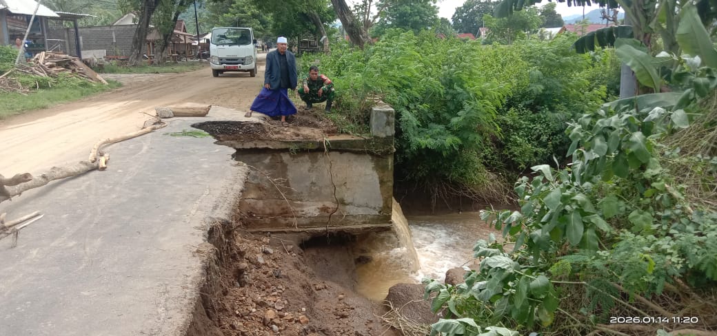 Kepala Desa Selong Belanak Kadir Jaelani menunjukkan kondisi ruas jalan dan jembatan yang nyaris putus di desanya, Rabu (14/1).