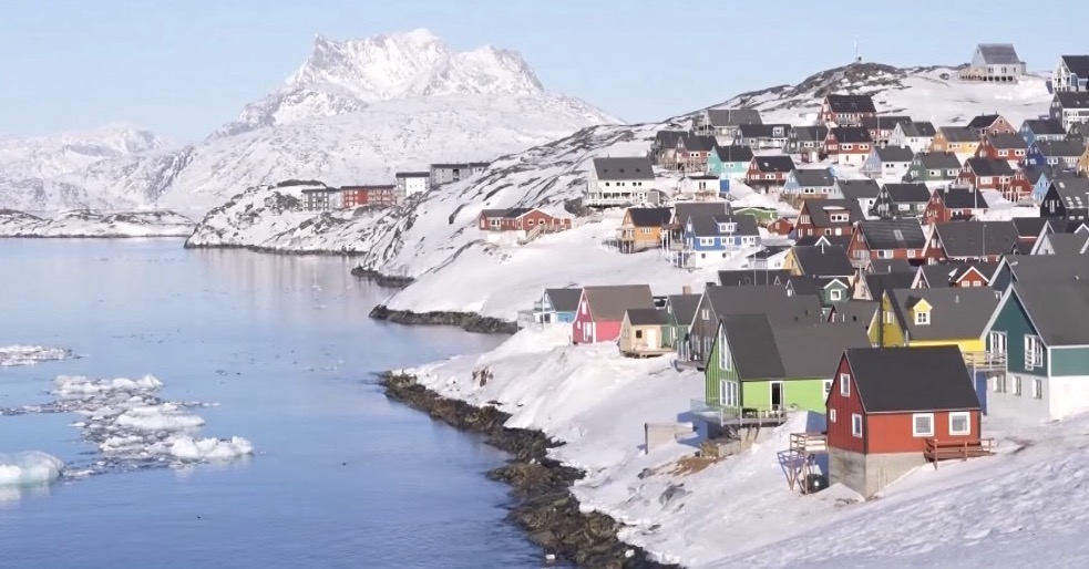 Deretan rumah warga di pesisir Nuuk, Greenland, dengan latar perairan Arktik yang mulai mencair akibat perubahan iklim.