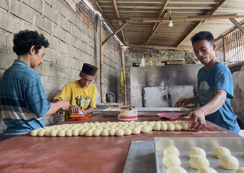 Harmaen (kanan), ayah, dan saudaranya tengah membentuk adonan roti.