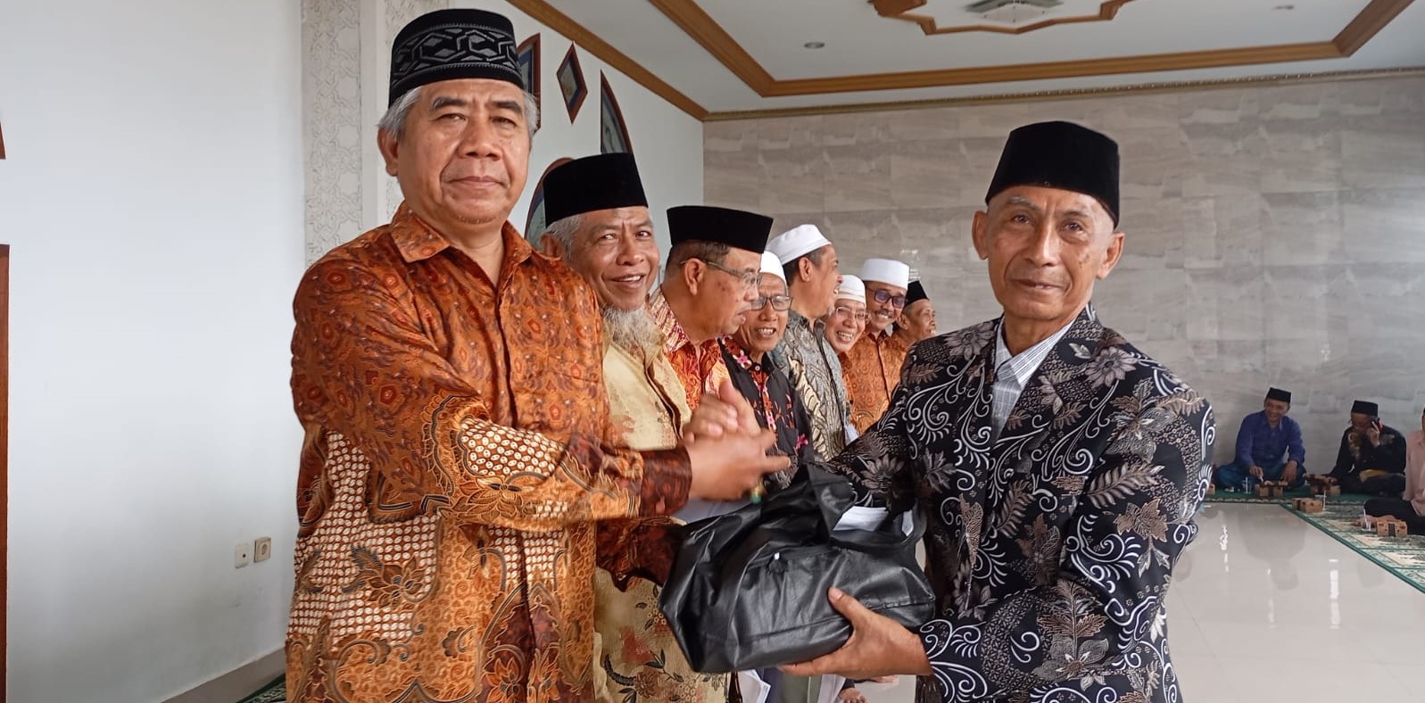 Ketua PWRI Lobar H Mahyudin (kanan) menyerahkan santunan secara simbolis kepada Ketua PWRI Lingsar Akhmad Adil di Masjid Qomarul Huda, Desa Lingsar, Sabtu (17/1). PWRI santuni ratusan yatim dan lansia