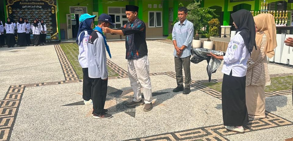 Kepala MAN 2 Mataram Sumber Hadi memasangkan topi kepada peserta sebagai tanda dibukanya ajang Lentera PMR Madya se-Pulau Lombok di madrasah setempat, belum lama ini. MAN 2 Mataram gelar Lentera PMR.