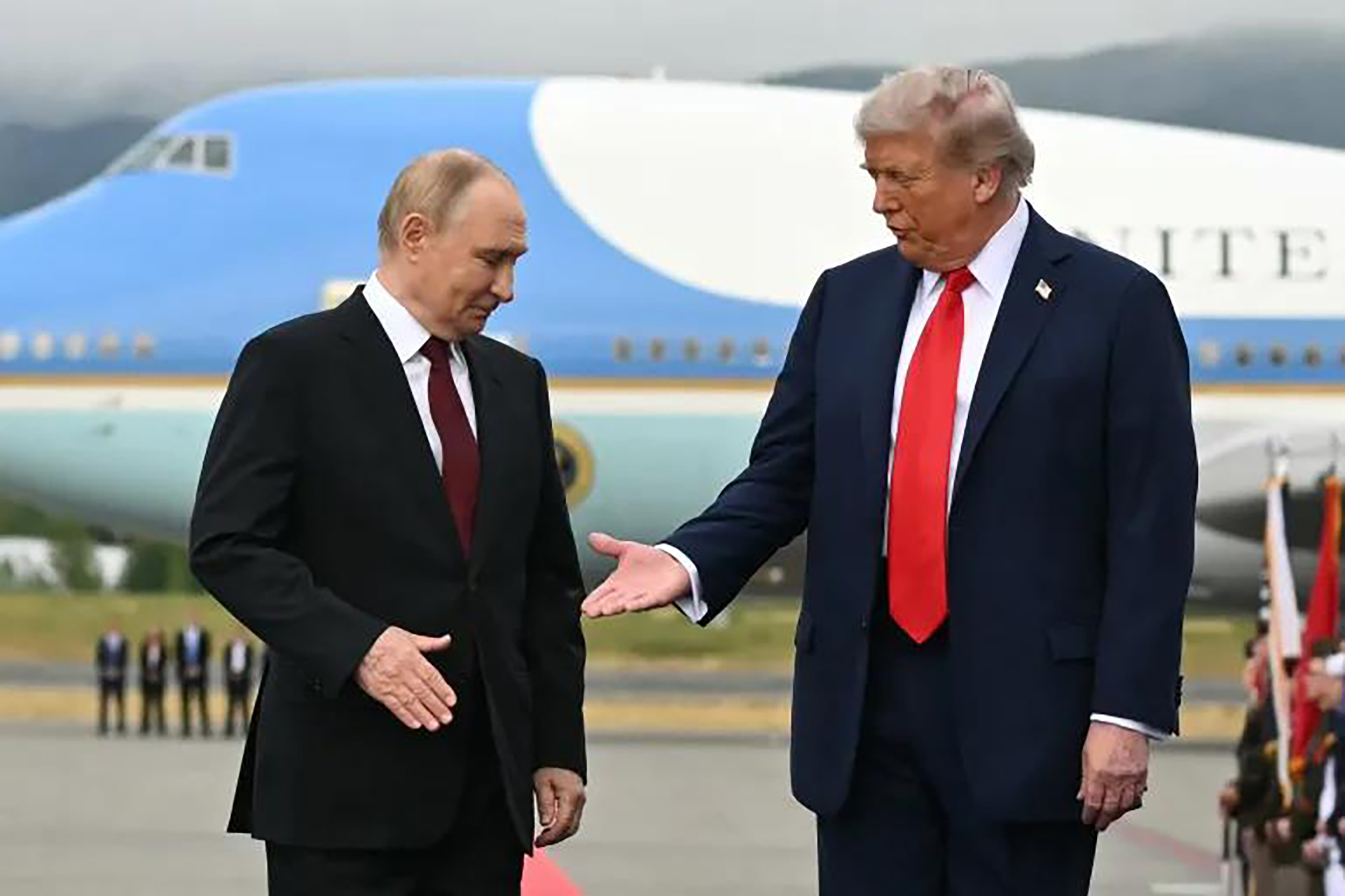 Presiden Amerika Serikat Donald Trump (kanan) mengulurkan tangan untuk berjabat tangan dengan Presiden Rusia Vladimir Putin pada 15 Agustus 2025, menjelang pertemuan puncak kedua pemimpin. (AFP)