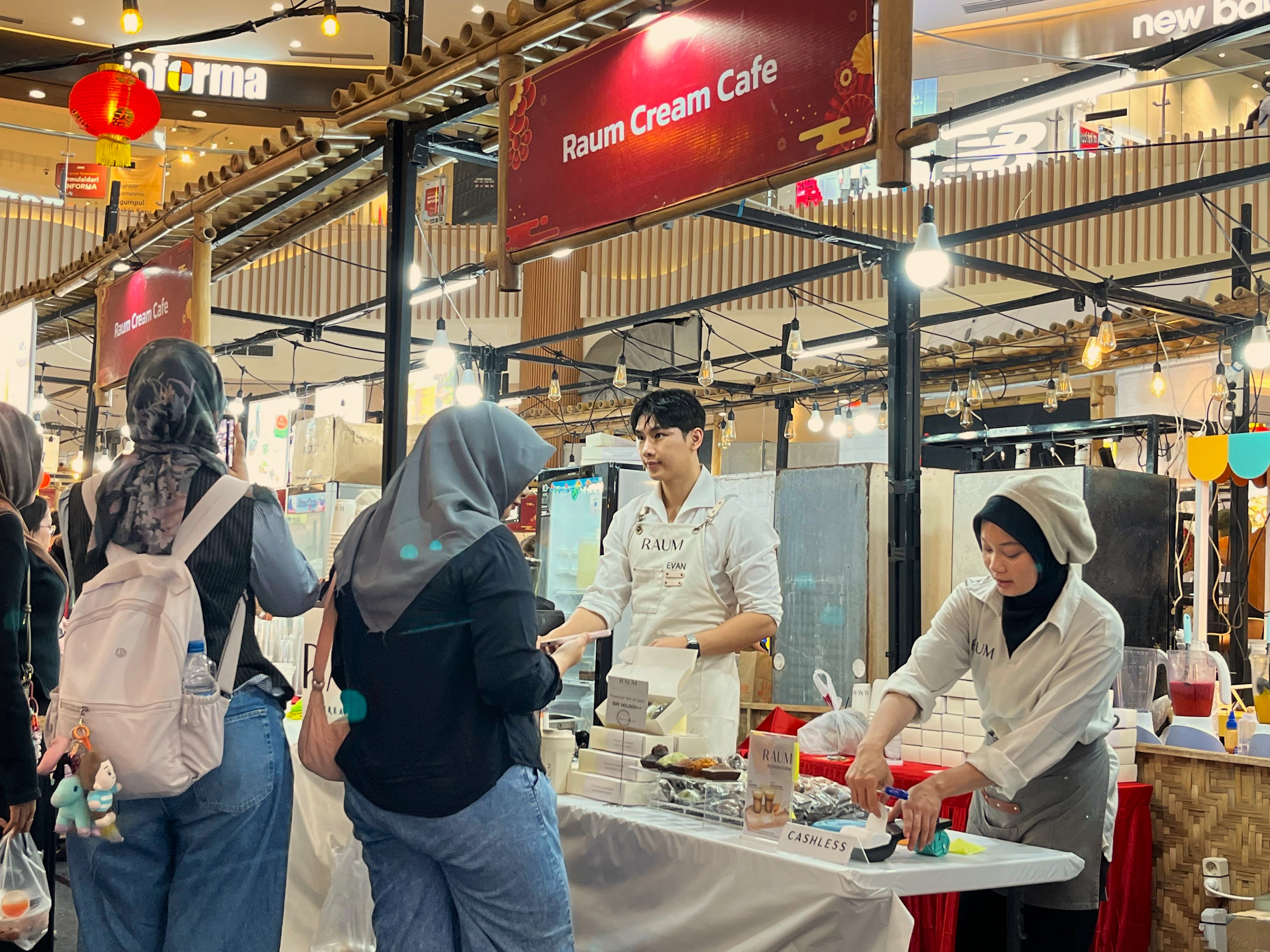LAYANI PEMBELI: Owner sekaligus Barista RAUM Cream Cafe Evan (kiri) saat melayani konsumen bersama stafnya di event  festival kuliner Imlek halal di Lombok Epicentrum Mall, Selasa (20/1)