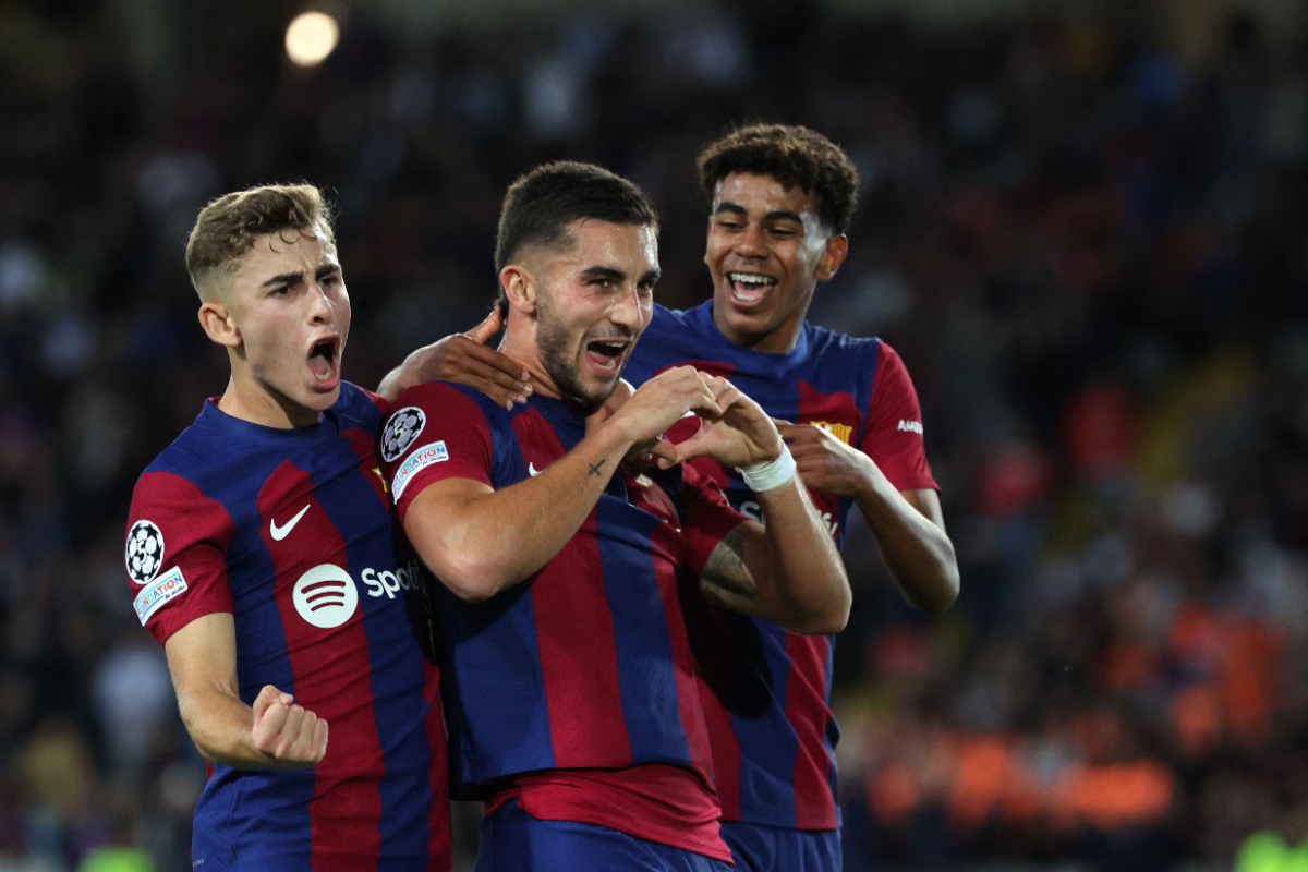 Striker Barcelona Ferran Torres (tengah) bersama Fermin Lopez (kiri) dan Lamine Yamal merayakan gol pembuka pertandingan Liga Champions melawan Slavia Praha.(Foto: LLUIS GENE/AFP)