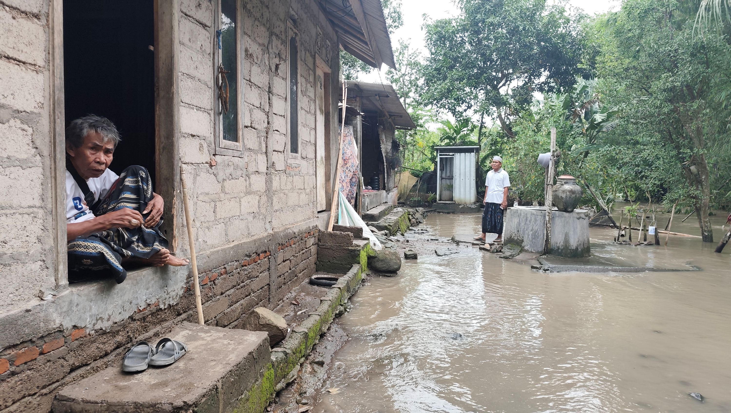 Risah setia tinggal di rumah miliknya ketika luapan air sungai mencapai setinggi pinggang orang dewasa saat hujan lebat di Dusun Tanak Rarang Barat, Desa Tanak Rarang, Praya Barat, Lombok Tengah