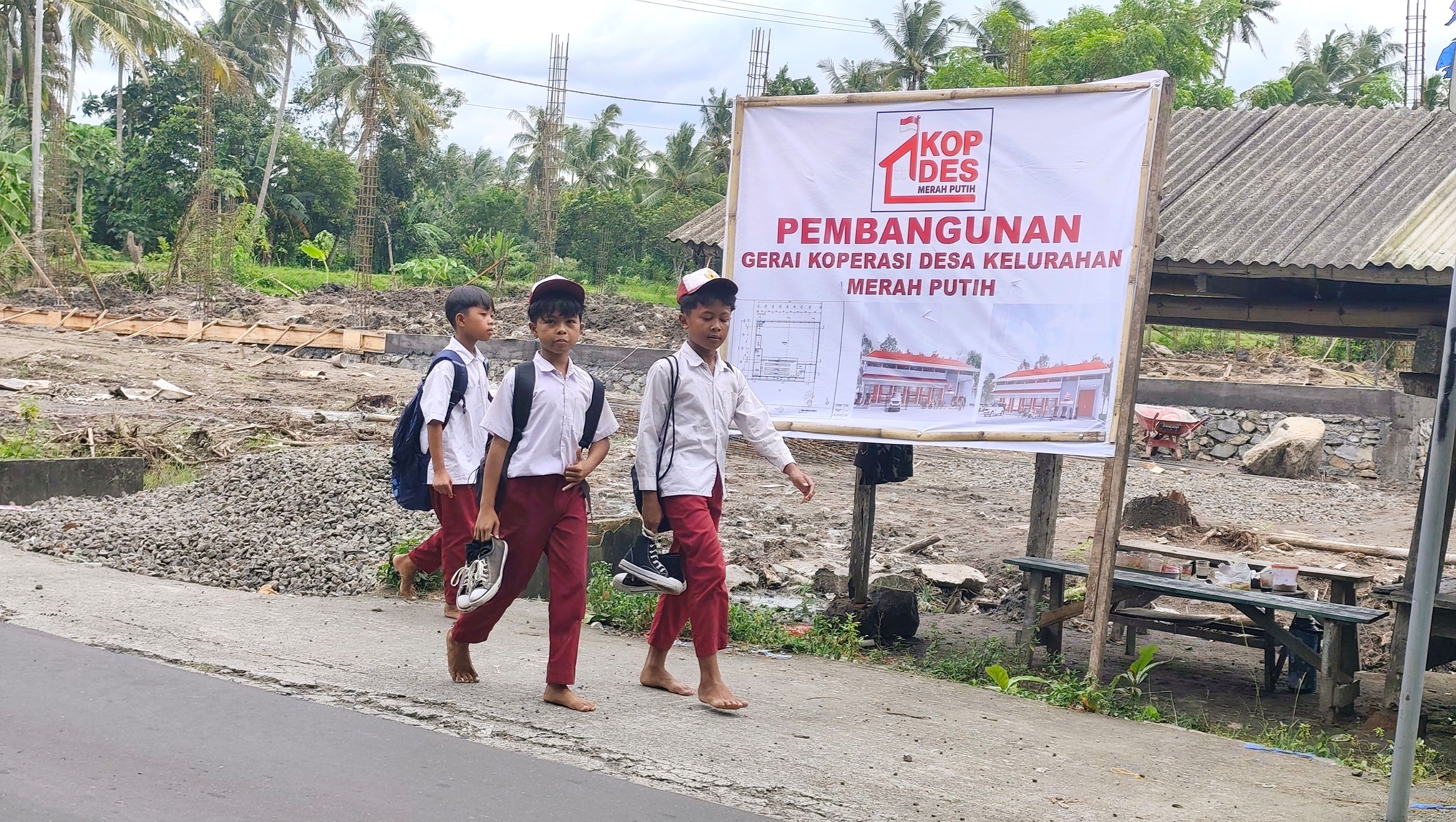 Tiga orang siswa berjalan kaki usai pulang sekolah di depan lokasi pembangunan Koperasi Desa Kelurahan Merah Putih (KDKMP) di Desa Bunkate, Jonggat, Lombok Tengah, Kamis (22/1).