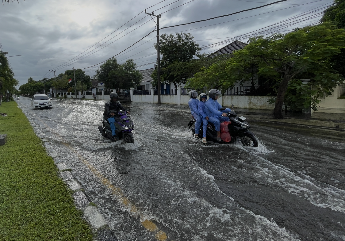 Kendaraan melintas susah payah di jalan Dr. Sujono, Lingkar Selatan, karena luapan air dari drainase.