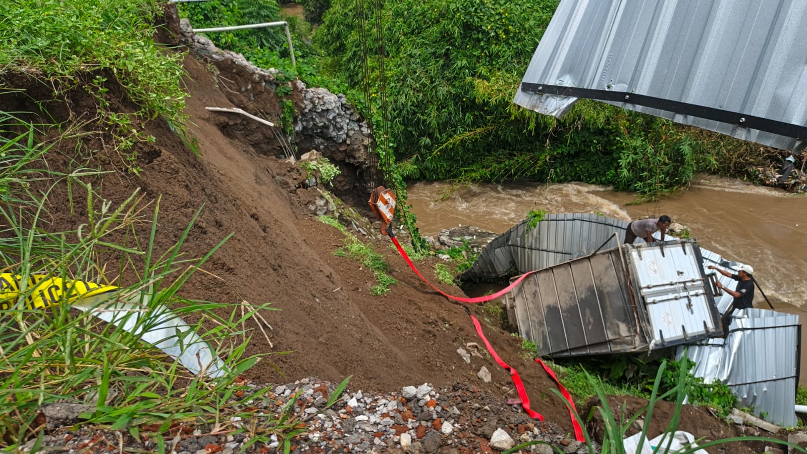 Mobil box yang jatuh ke dasar sungai akibat tebing longsor di belakang kompleks pertokoan Dokter Wahidin.