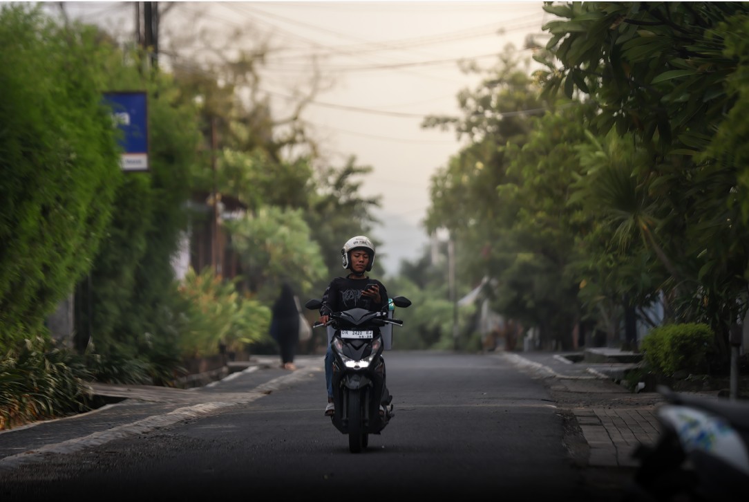 CARI ALAMAT: Seorang kurir sedang mencari alamat tujuan di sebuah kompleks perumahan di Kota Mataram, Jumat (23/1)