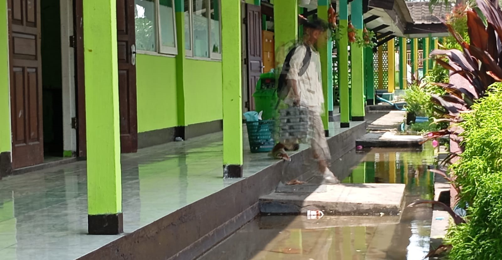 Siswa SMPN 10 Mataram melintas di depan kelas yang tergenang, Jumat (23/1). Cuaca ekstrem rendam sejumlah ruang kelas, KBM tetap berjalan. Ruang kelas tergenang, KBM SMPN 10 Mataram tetap berjalan.