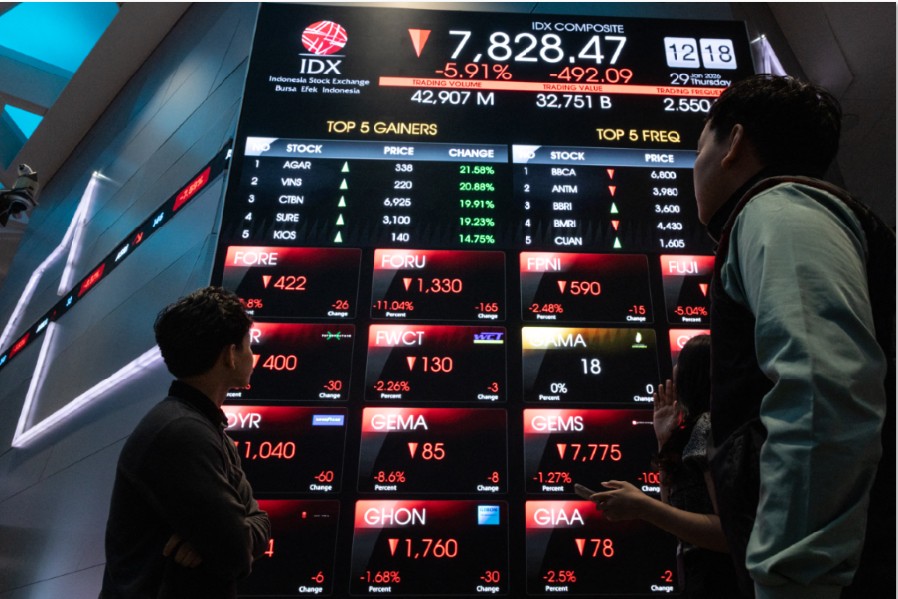 PANTAU PERGERAKAN SAHAM: Orang-orang melihat papan elektronik yang menampilkan harga saham di Bursa Efek Indonesia (BEI) di Jakarta pada Kamis (29/1).
